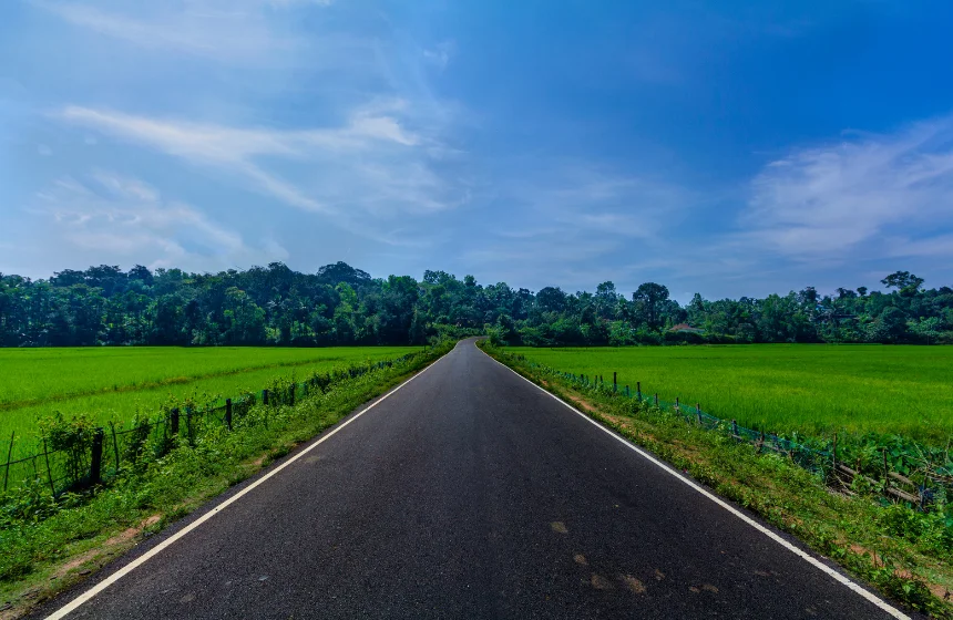 scenic-view-of-road-amidst-field-against-sky-sakleshpur-india