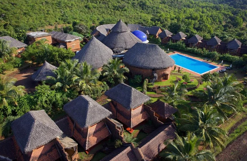 ecofriendly huts and a swimming pool along with greenery