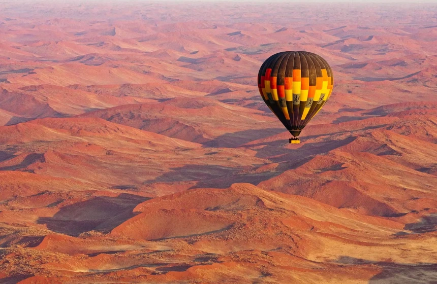 Air balloons floating top of a desert