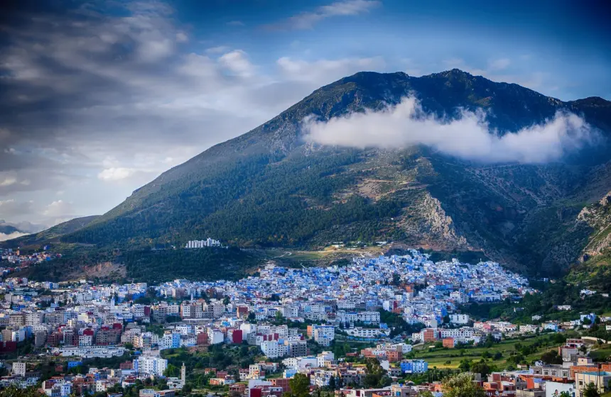 full of blue coloured houses in the bottom of a mountain