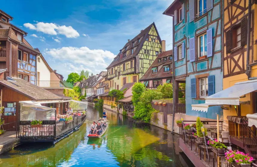 buildings near river and a boat moving in it