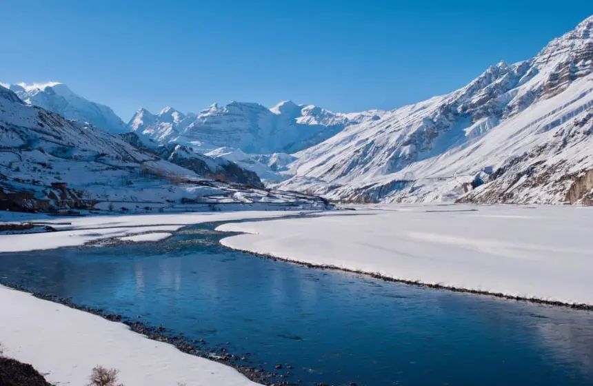 a river flowing surrounded by mist and mountain